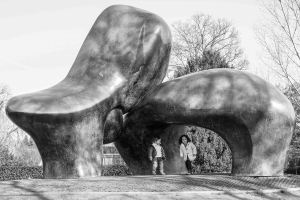 Kids play around under the soft forms of a henry Moore sculpture in Zurich.